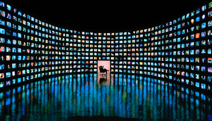 Person in Room with 500 Monitors