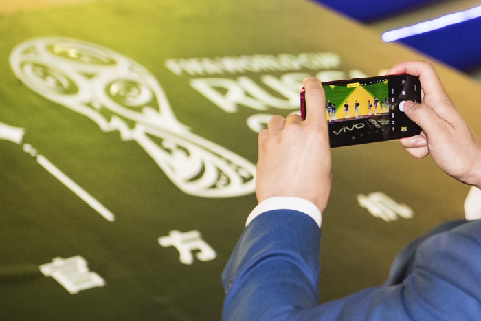A Vivo Super Fan Photographer taking a picture of the launch event with a Vivo smartphone