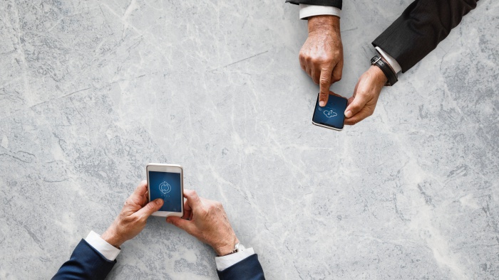 Business people syncing data by mobile phone